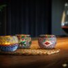3x theelichthouder multi color van dorsetto 9 cm op onderzetter met wijnglas
