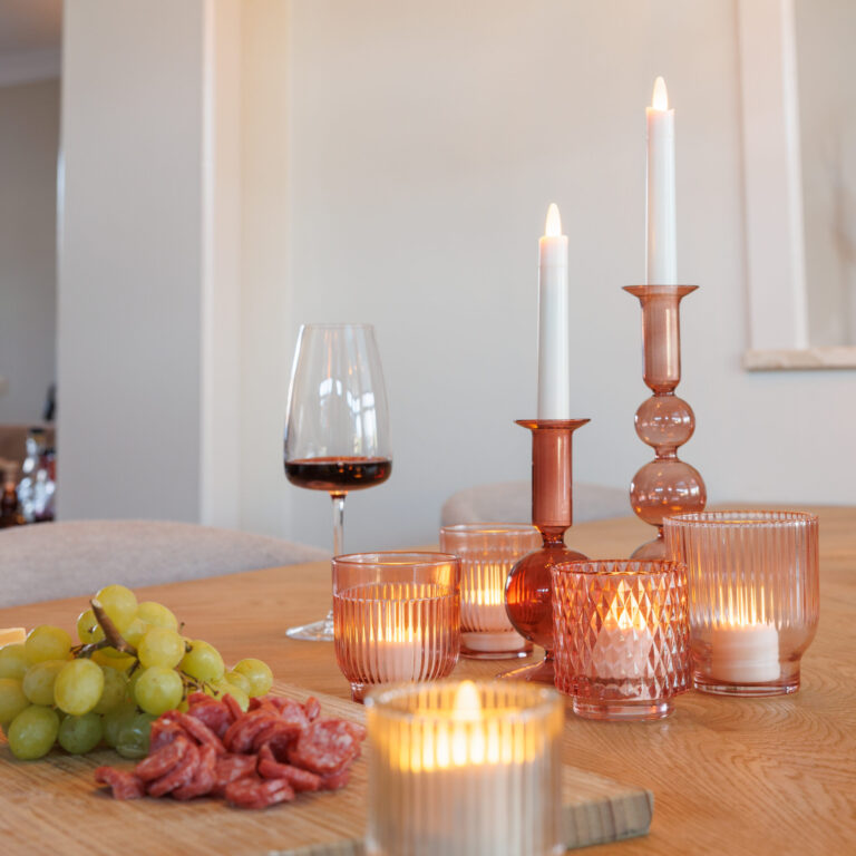 dorsetto waxinelichtjes op een tafel bij een wijnglas en borrelplank